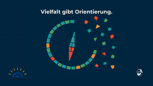Visual im Mosaik-Stil: Aus bunten Einzelteilen entsteht ein unvollständiger Kompass auf dunkelblauem Hintergrund. Die Kompassnadel ist bereits zusammengesetzt, einige bunte Mosaiksteine liegen noch ungeordnet außerhalb des Kreises. Oben steht der Text: „Vielfalt gibt Orientierung.“